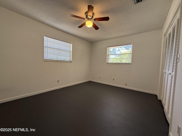 unfurnished bedroom with a closet, baseboards, visible vents, ceiling fan, and a textured ceiling