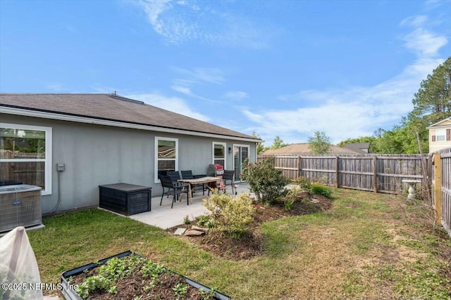 view of yard with a fenced backyard, central AC unit, and a patio area