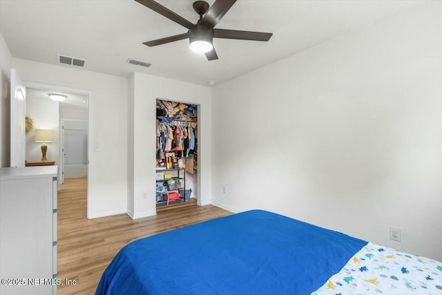 bedroom featuring wood finished floors, visible vents, baseboards, and ceiling fan