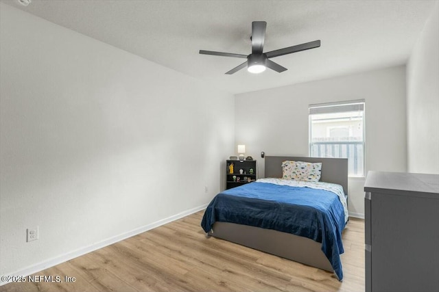 bedroom with a ceiling fan, baseboards, and light wood-style floors