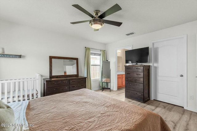 bedroom featuring baseboards, light wood-style floors, and visible vents