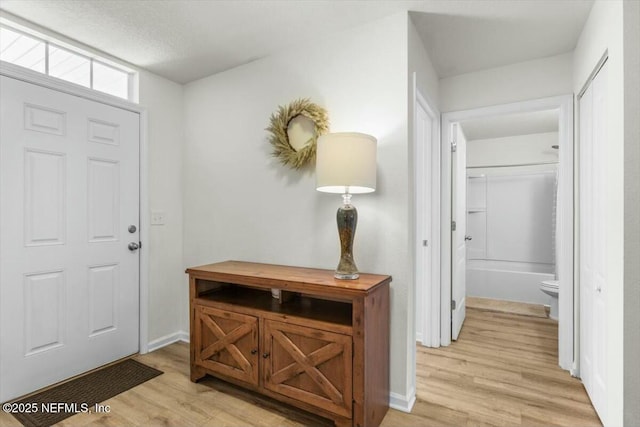 entryway featuring baseboards and light wood finished floors