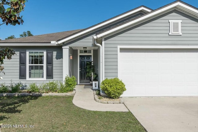 view of front of home featuring a garage, a shingled roof, a front lawn, and concrete driveway