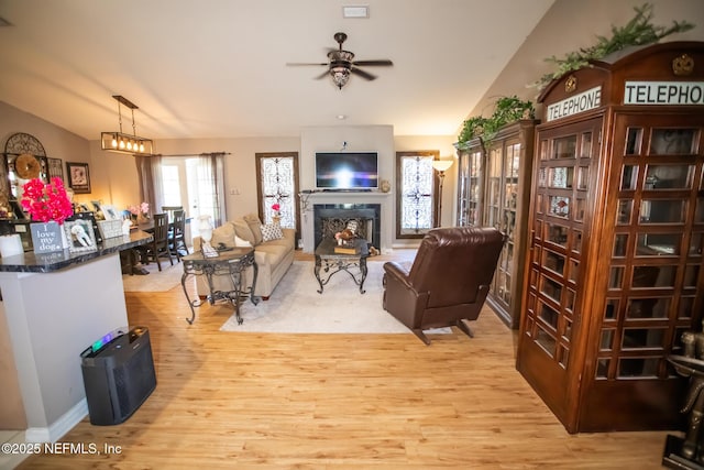 4565 SE 3rd Pl, Keystone Heights, FL 32656 - living room featuring a ceiling fan, vaulted ceiling, light wood-style floors, and a fireplace