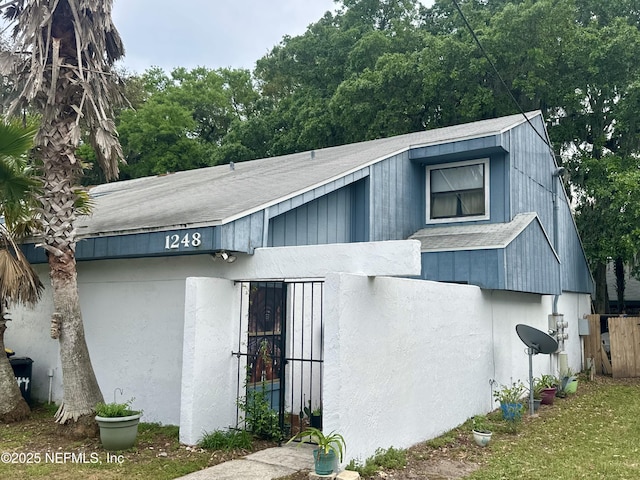 view of side of property featuring a shingled roof