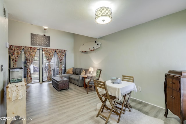 dining space featuring baseboards, light wood-type flooring, and visible vents