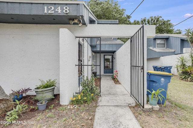 entrance to property with a gate and stucco siding