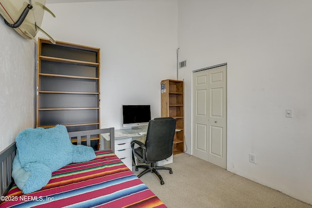 office area with a high ceiling, carpet flooring, and visible vents