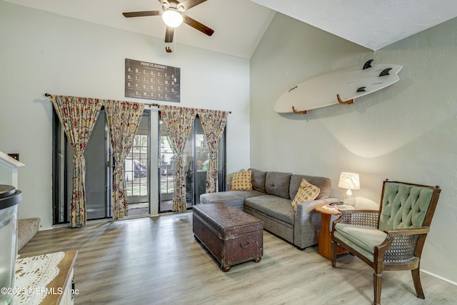 living room featuring a ceiling fan, vaulted ceiling, and wood finished floors