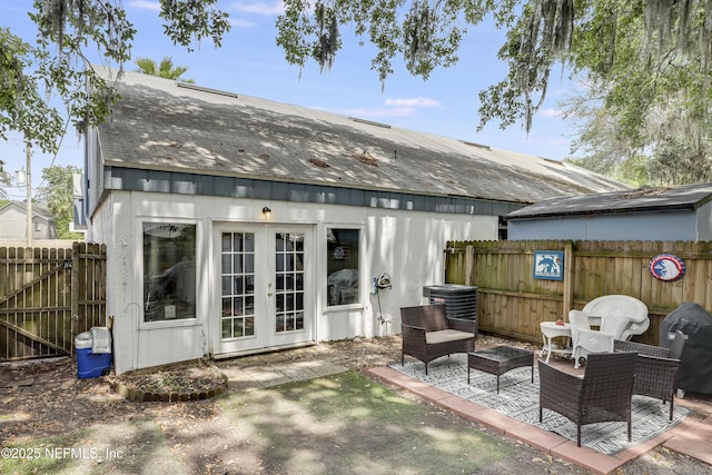 rear view of house with cooling unit, a fenced backyard, french doors, a shingled roof, and a patio area