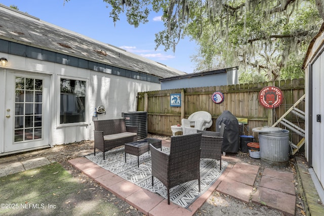 view of patio with central air condition unit and fence