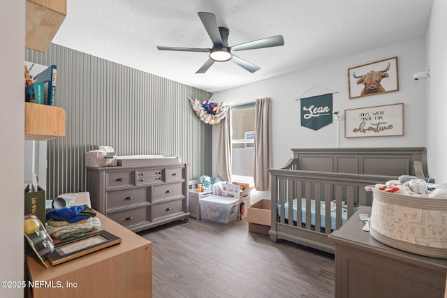 2916 Duck Hollow Ln, Green Cove Springs, FL 32043 - bedroom with wood finished floors, a crib, a ceiling fan, and a textured ceiling