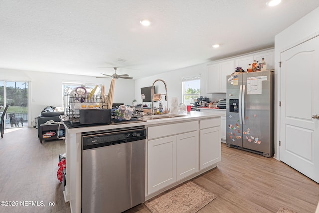 2916 Duck Hollow Ln, Green Cove Springs, FL 32043 - kitchen featuring stainless steel appliances, an island with sink, light wood-type flooring, white cabinets, and a ceiling fan