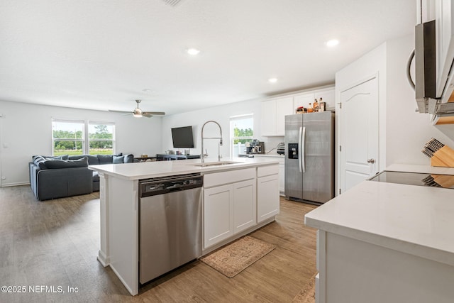 2916 Duck Hollow Ln, Green Cove Springs, FL 32043 - kitchen featuring stainless steel appliances, a sink, open floor plan, white cabinets, and light countertops