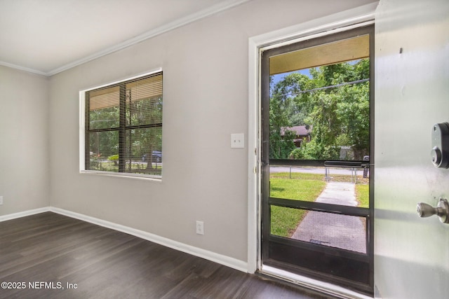doorway with dark wood-type flooring, baseboards, and ornamental molding