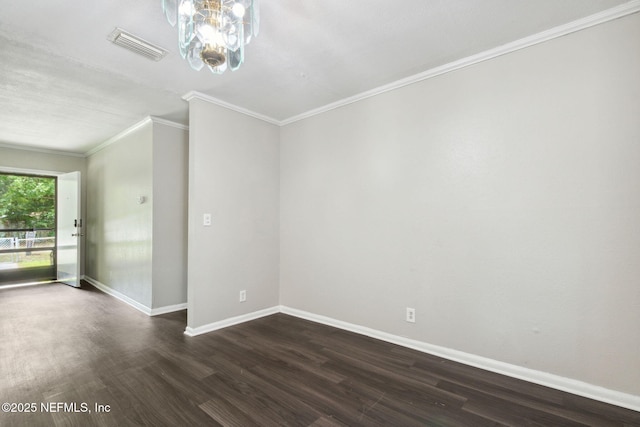 spare room featuring dark wood-type flooring, visible vents, baseboards, and ornamental molding