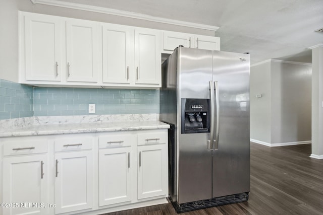 kitchen with white cabinets, baseboards, stainless steel refrigerator with ice dispenser, ornamental molding, and backsplash