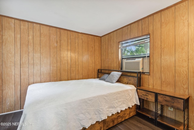 bedroom with cooling unit, crown molding, wood finished floors, and wood walls