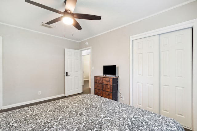 bedroom featuring crown molding, ceiling fan, a closet, visible vents, and wood finished floors