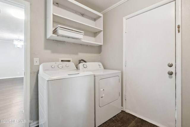 laundry area featuring baseboards, washing machine and dryer, dark wood-style floors, crown molding, and laundry area