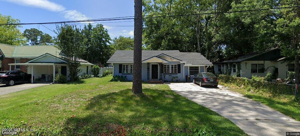 ranch-style house with concrete driveway and a front yard