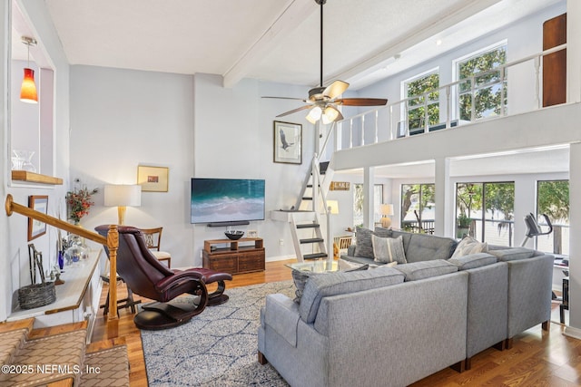 6470 Brooklyn Bay Rd, Keystone Heights, FL 32656 - living room with stairs, wood finished floors, beam ceiling, a ceiling fan, and a towering ceiling