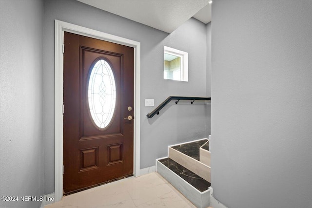 foyer featuring stairs and marble finish floor