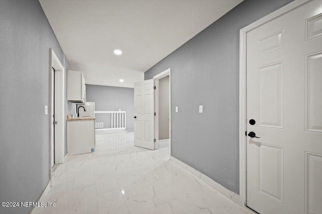 hall with visible vents, a sink, baseboards, marble finish floor, and recessed lighting