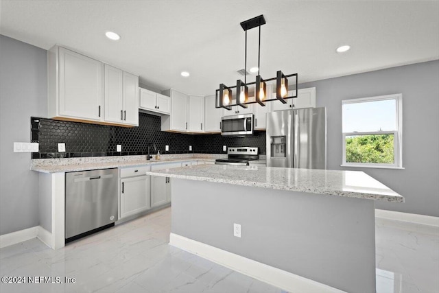 kitchen with marble finish floor, baseboards, white cabinets, tasteful backsplash, and stainless steel appliances
