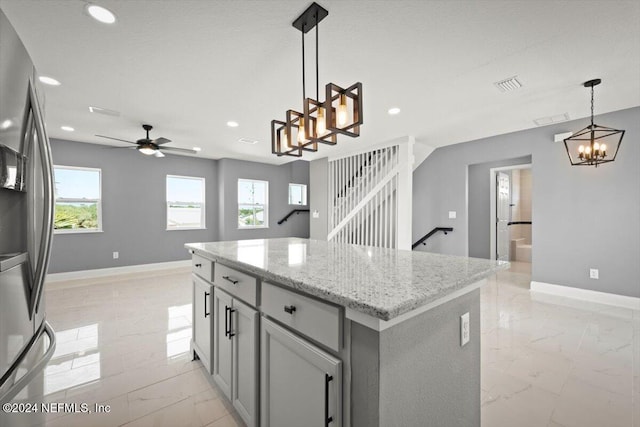 kitchen featuring marble finish floor, baseboards, visible vents, and stainless steel fridge with ice dispenser
