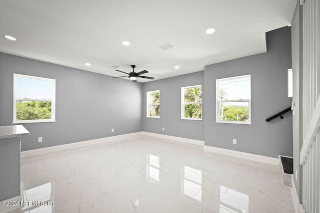 empty room with baseboards, recessed lighting, and marble finish floor