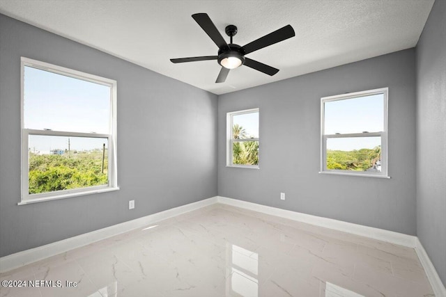unfurnished room featuring baseboards, ceiling fan, and marble finish floor