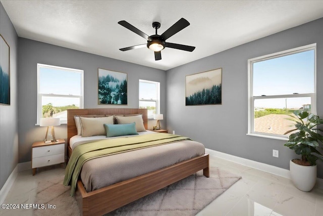 bedroom featuring baseboards, multiple windows, and marble finish floor