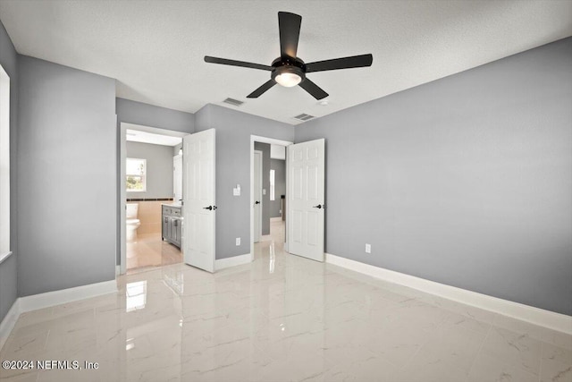 unfurnished bedroom featuring baseboards, visible vents, ensuite bathroom, and marble finish floor