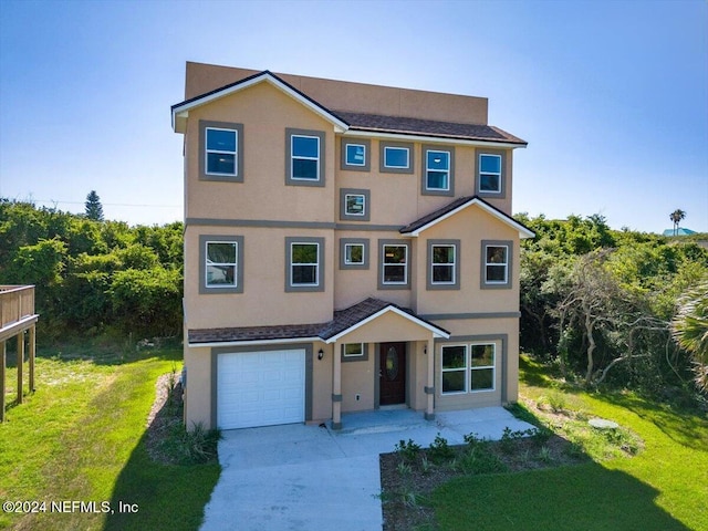 view of front of property with stucco siding, concrete driveway, a front yard, and a garage