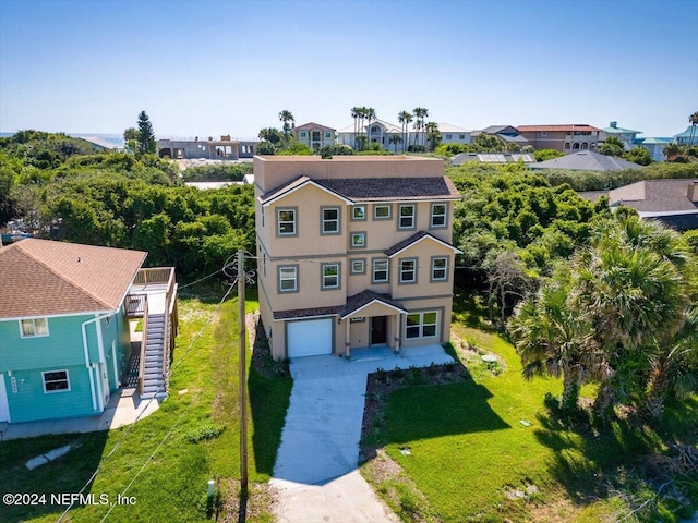 view of front of property with a front lawn, a garage, stucco siding, stairway, and driveway