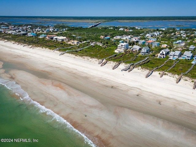 drone / aerial view featuring a beach view, a residential view, and a water view