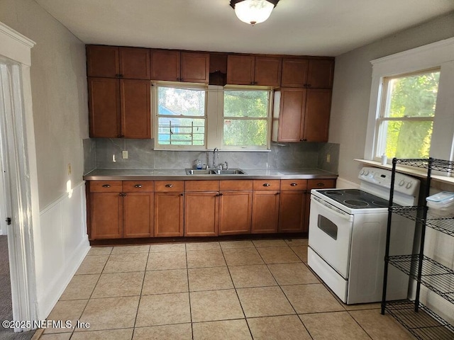 2138 Park St, Jacksonville, FL 32204 - kitchen featuring white electric stove, a sink, brown cabinets, and tasteful backsplash