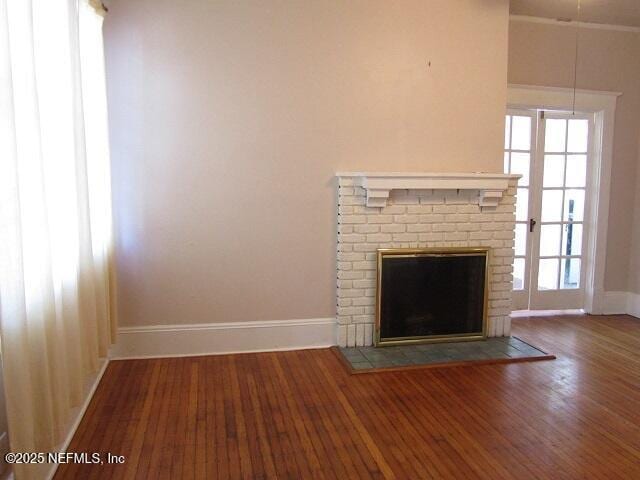 2138 Park St, Jacksonville, FL 32204 - unfurnished living room with hardwood / wood-style floors, a brick fireplace, baseboards, and a wealth of natural light