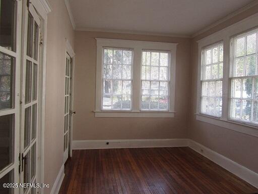 2138 Park St, Jacksonville, FL 32204 - empty room featuring dark wood-type flooring, crown molding, and baseboards