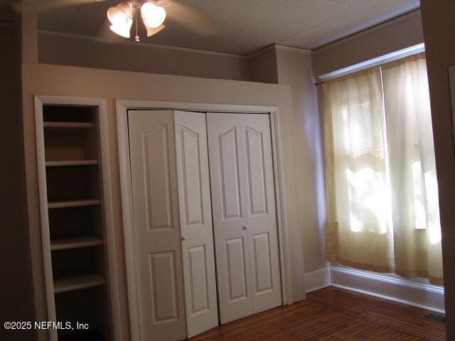 2138 Park St, Jacksonville, FL 32204 - unfurnished bedroom with wood finished floors, a closet, and ornamental molding