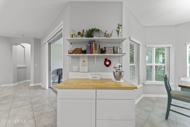 3422 Oglebay Dr, Green Cove Springs, FL 32043 - kitchen with light tile patterned floors, a textured ceiling, open shelves, white cabinetry, and baseboards