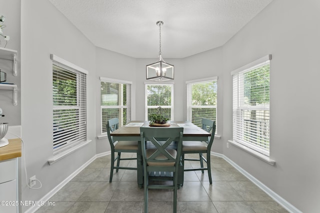 3422 Oglebay Dr, Green Cove Springs, FL 32043 - dining room with a textured ceiling, light tile patterned floors, baseboards, and an inviting chandelier