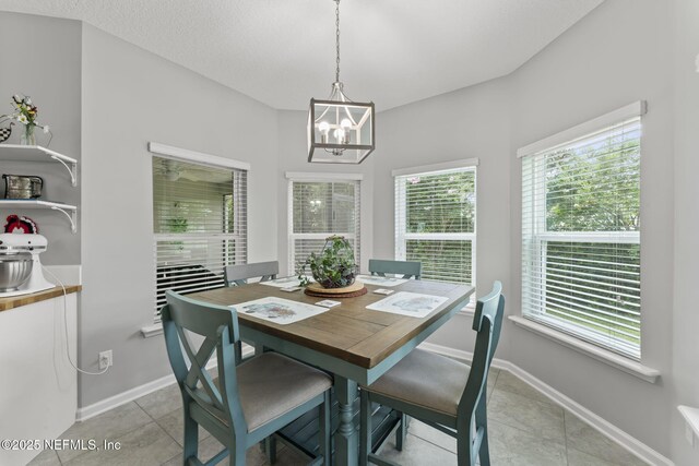 3422 Oglebay Dr, Green Cove Springs, FL 32043 - dining room with light tile patterned flooring, an inviting chandelier, and baseboards