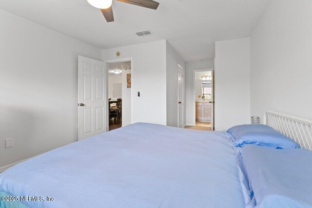 7800 Point Meadows Dr Unit 1035, Jacksonville, FL 32256 - bedroom with ensuite bath, ceiling fan, and baseboards