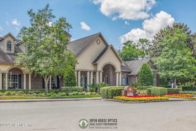 7800 Point Meadows Dr Unit 1035, Jacksonville, FL 32256 - view of front facade featuring brick siding, a shingled roof, and stucco siding