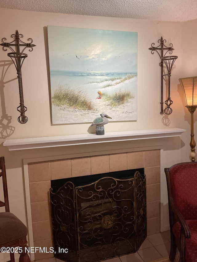 room details featuring a tiled fireplace and a textured ceiling