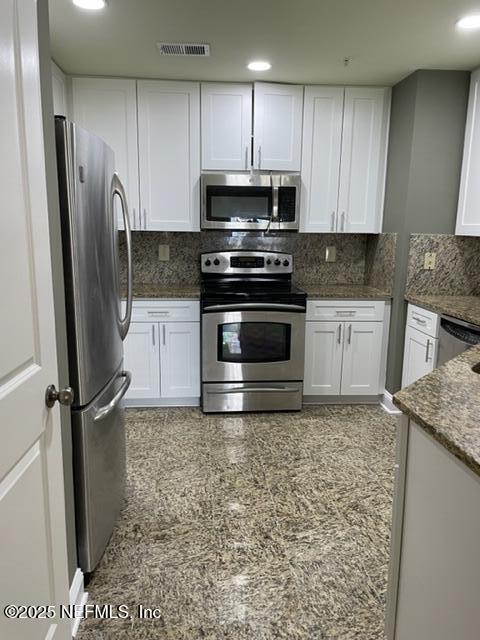 400 E Bay St Unit 502, Jacksonville, FL 32202 - kitchen featuring white cabinets, visible vents, decorative backsplash, and appliances with stainless steel finishes
