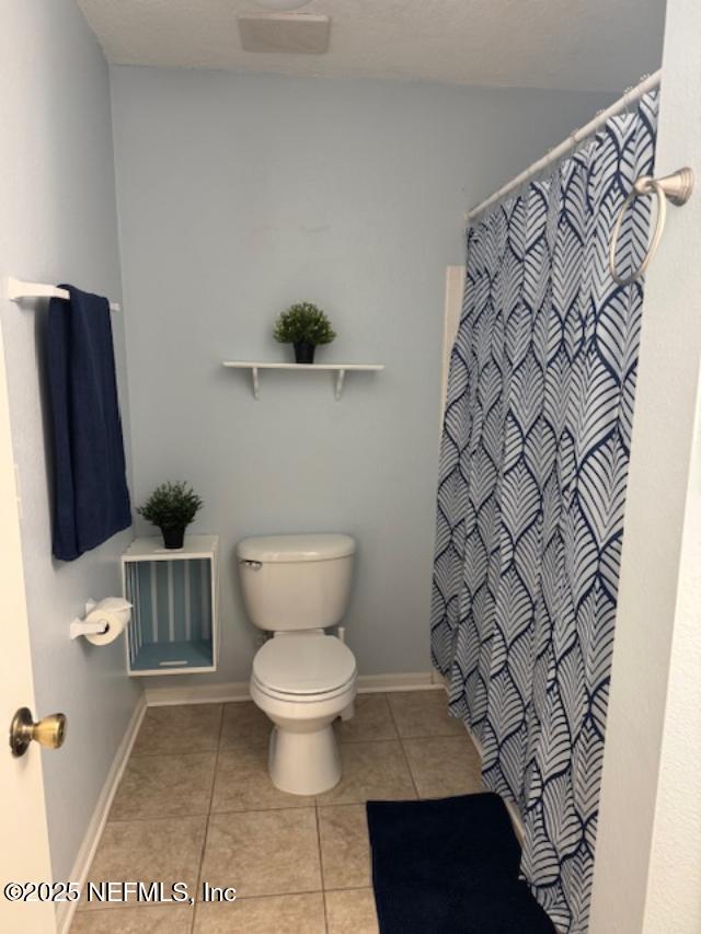 7701 Timberlin Park Blvd Unit 531, Jacksonville, FL 32256 - bathroom with tile patterned flooring, toilet, a shower with shower curtain, and baseboards