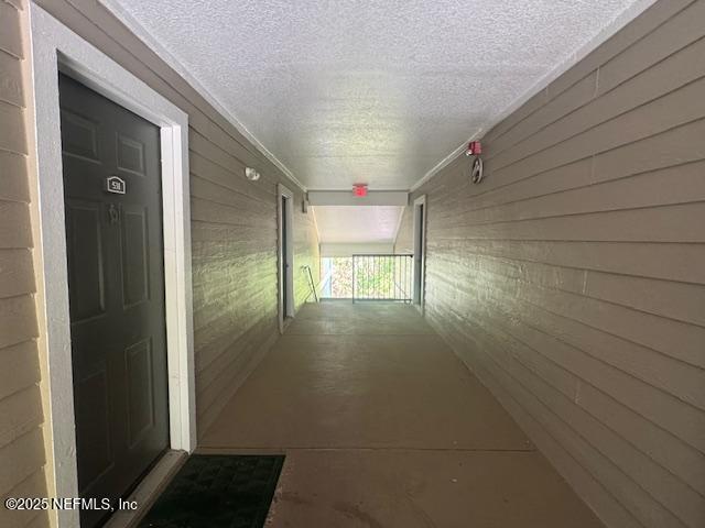 7701 Timberlin Park Blvd Unit 531, Jacksonville, FL 32256 - corridor with a textured ceiling and wooden walls